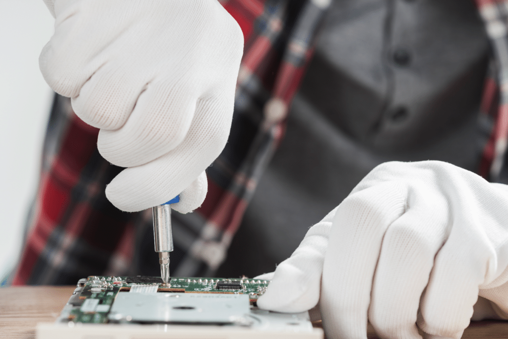 technician repairing computer motherboard with screwdriver